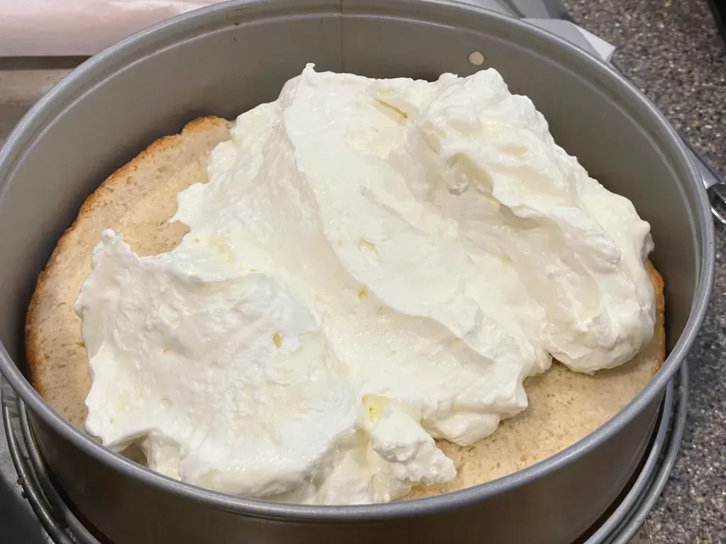 Die Creme-Mischung auf dem Kuchenboden verteilen