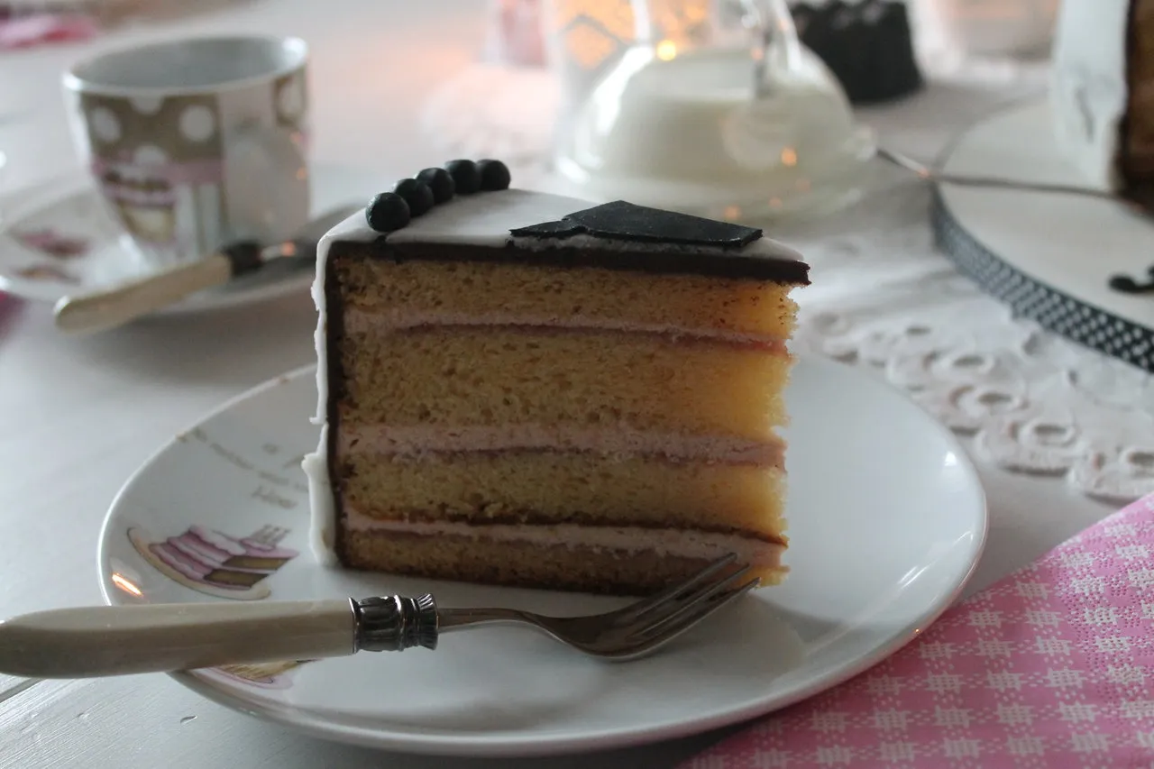 Die fertige Geburtstagstorte mit einem Maler-Motiv aus Fondant und kleinen Farbtuben als Dekoration