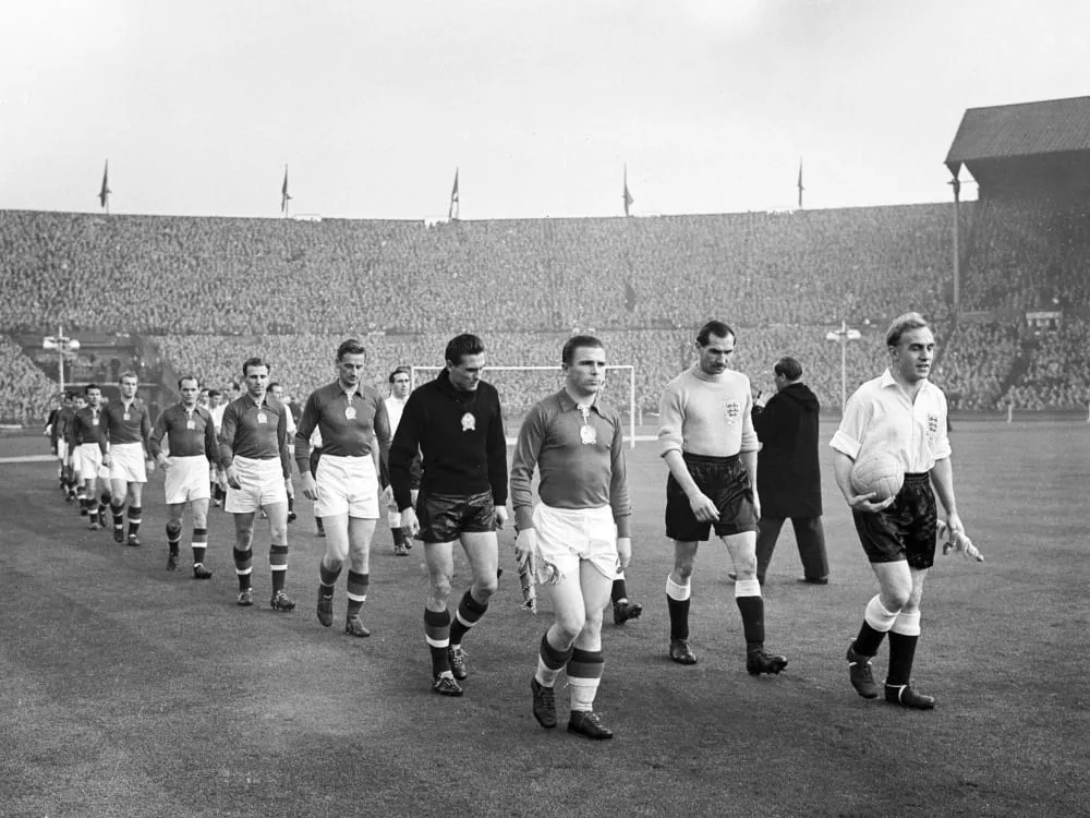 Die Kapitäne Puskas und Wright führen ihre Mannschaften auf den Platz