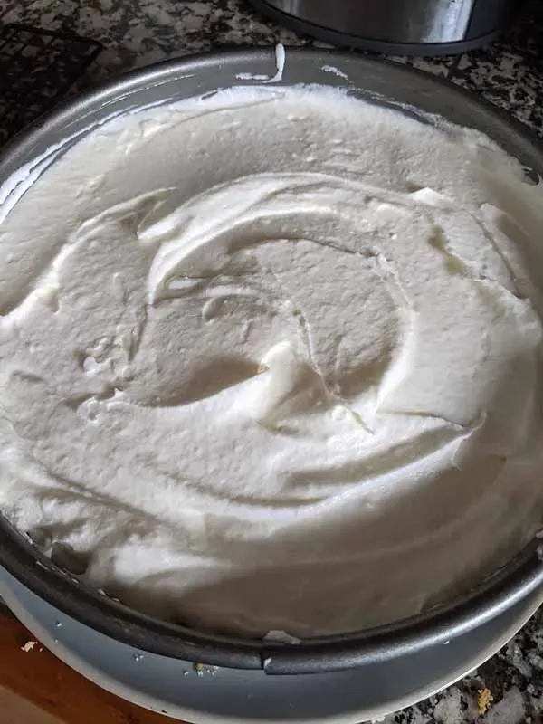 Die Käse Sahne Torte Füllung wird auf dem Boden verteilt