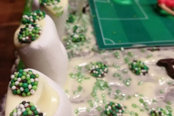 Die Seitenansicht des Fußballkuchens mit bunten Süßigkeiten dekoriert