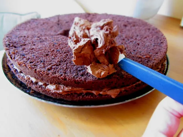 Die zweite Kuchenschicht wird aufgesetzt und ebenfalls mit Creme bestrichen