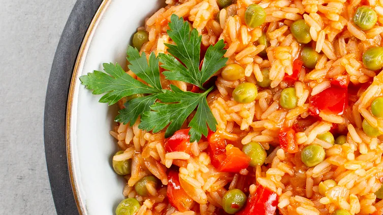 Djuveč-Reis in einer Schüssel, mit frischen Kräutern garniert.