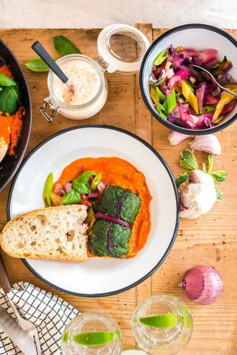 Drei Mangold Rouladen, appetitlich angerichtet mit frischer Paprikasauce