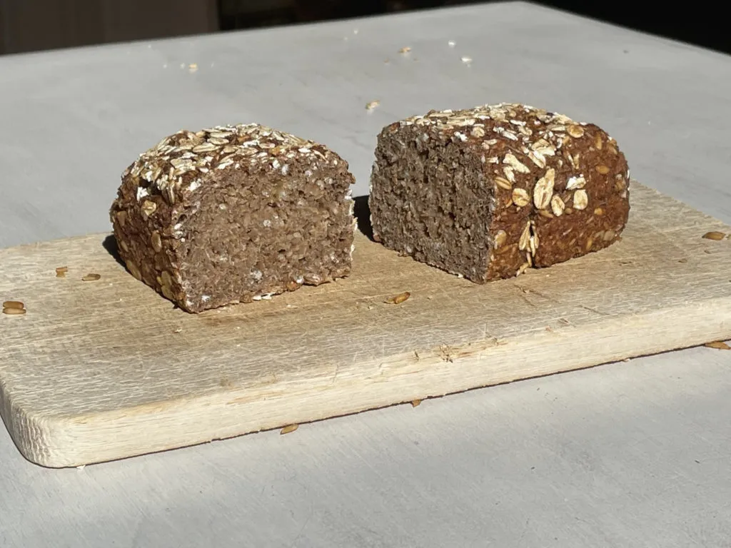 Drei Scheiben Hamburger Schwarzbrot auf einem Holzbrett