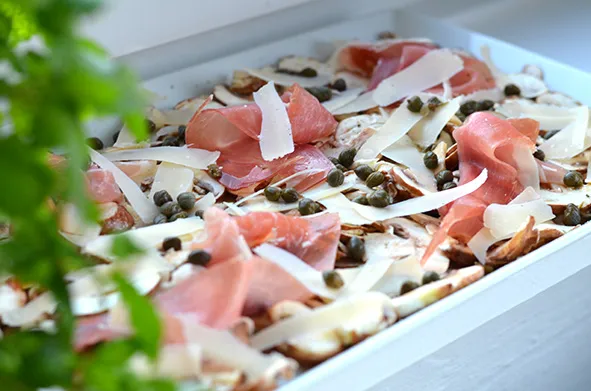 Dünn geschnittenes Champignon-Carpaccio mit Käse und Kapern