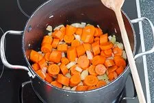 Dünsten: Möhren und Zwiebeln in einem Topf mit Pflanzenöl