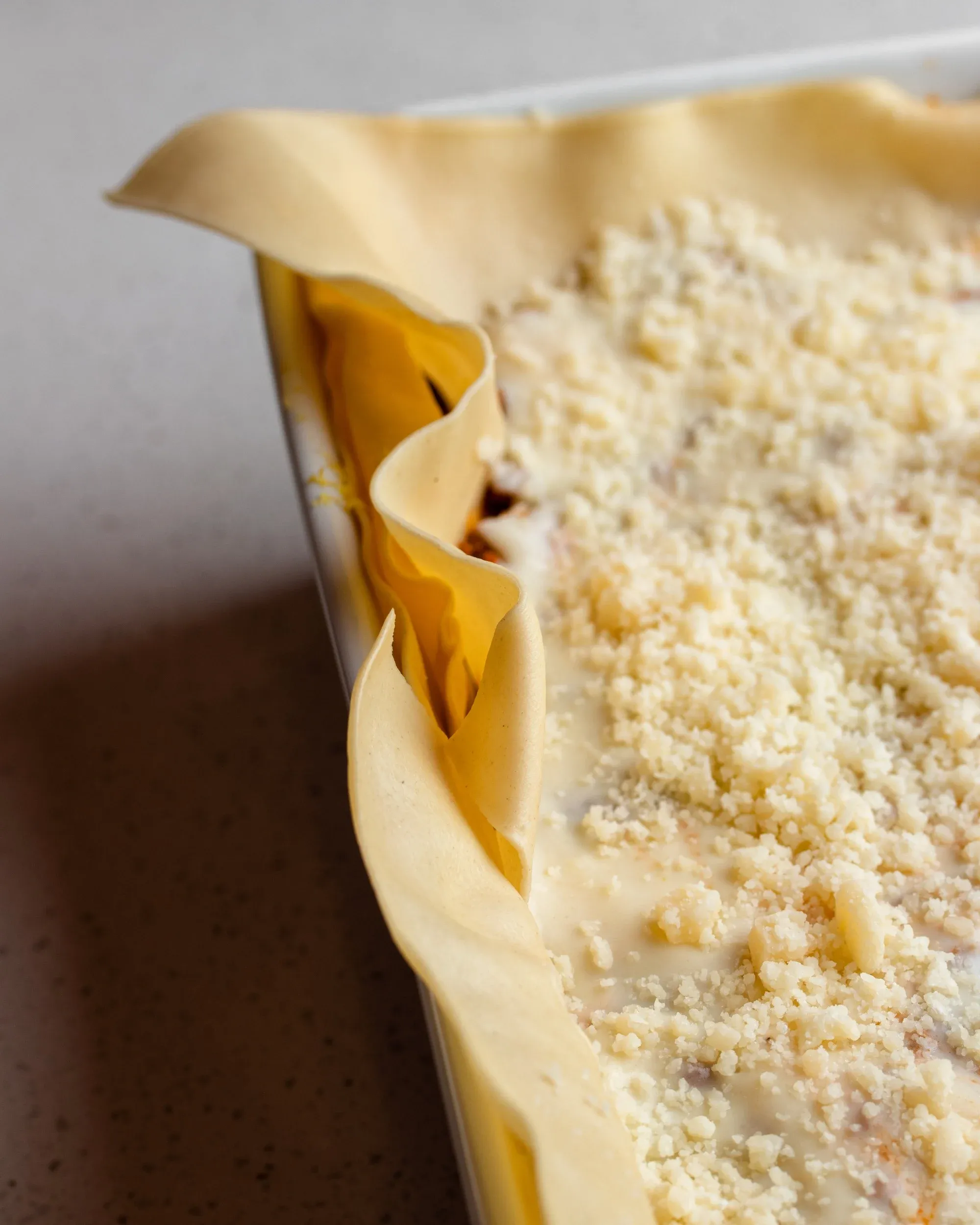 Ecke der zusammengebauten Lasagne, die die überhängende Pasta zeigt