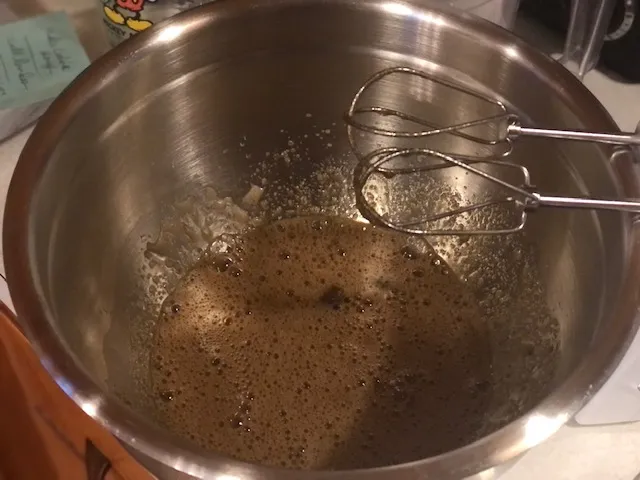 Eier, Wasser und dunkler brauner Zucker in einer Glasschüssel, noch nicht gut vermischt.