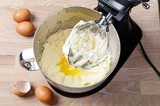 Eier werden einzeln in die Butter-Zucker-Creme eingerührt