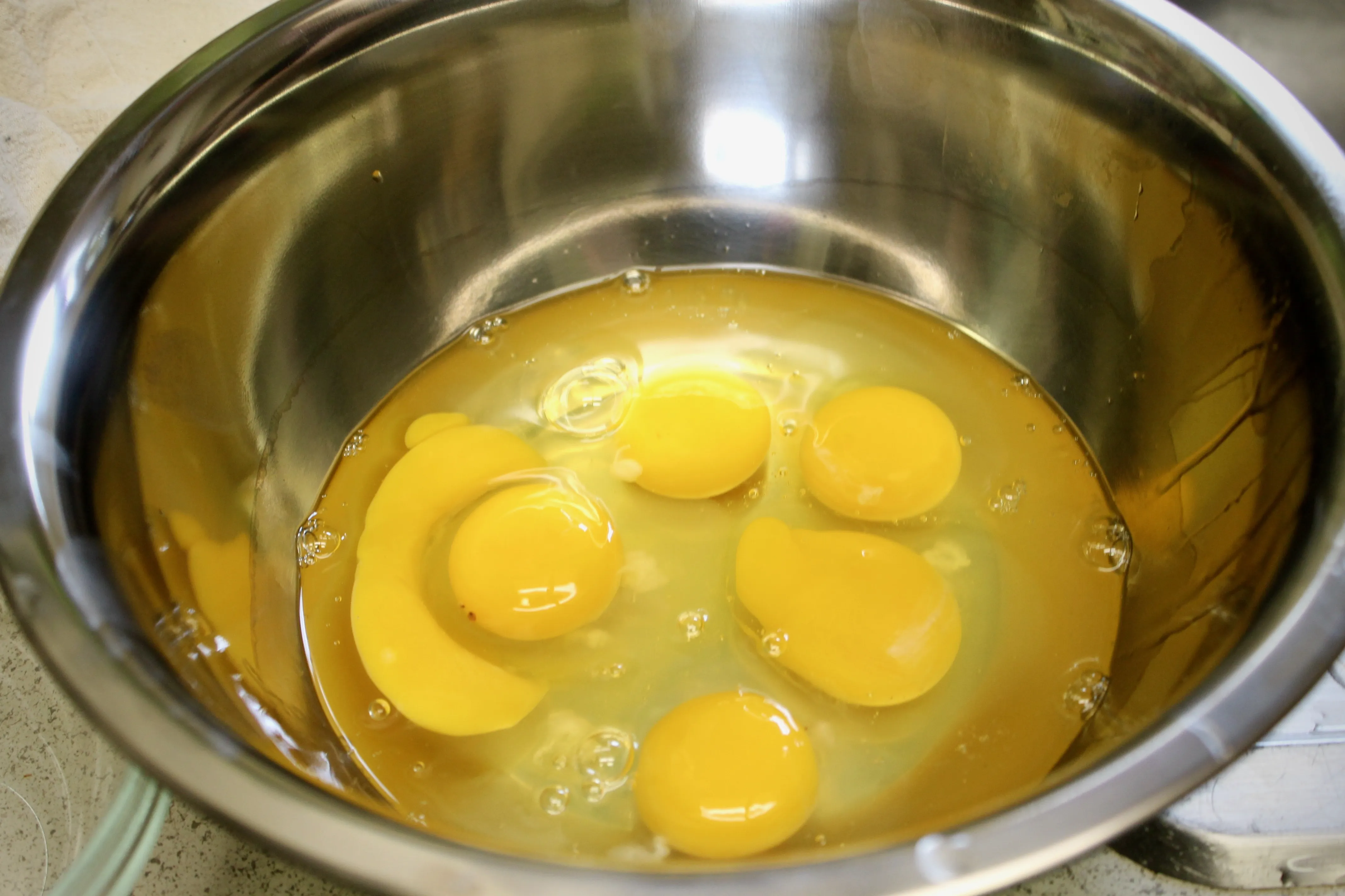 Eier werden in eine Schüssel geschlagen, bereit zur Verwendung