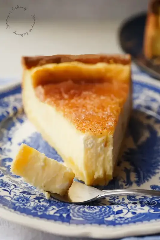 Ein aufgeschnittenes Stück Rahmkuchen, das die cremige Füllung und den knusprigen Boden zeigt