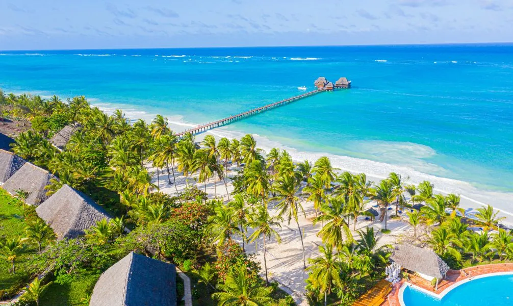 Ein Boot auf dem türkisblauen Meer vor Sansibar bei Sonnenuntergang