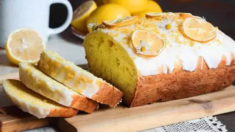 Ein erfrischender Zitronenkuchen aus der Kastenform, glasiert und mit frischen Zitronenscheiben dekoriert