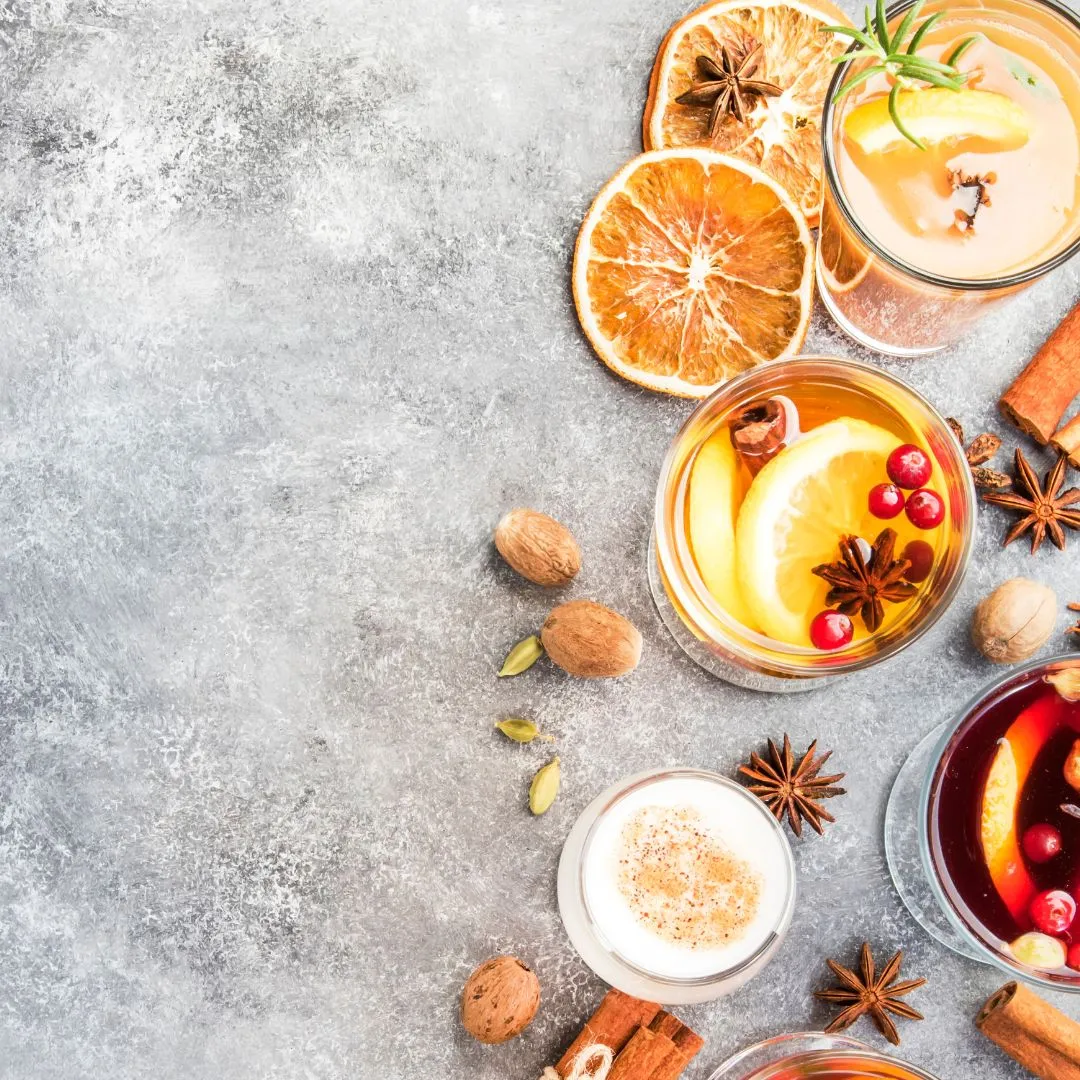 Ein Glas Apfel-Zimt-Punsch mit getrockneten Apfelscheiben und Zimtstangen