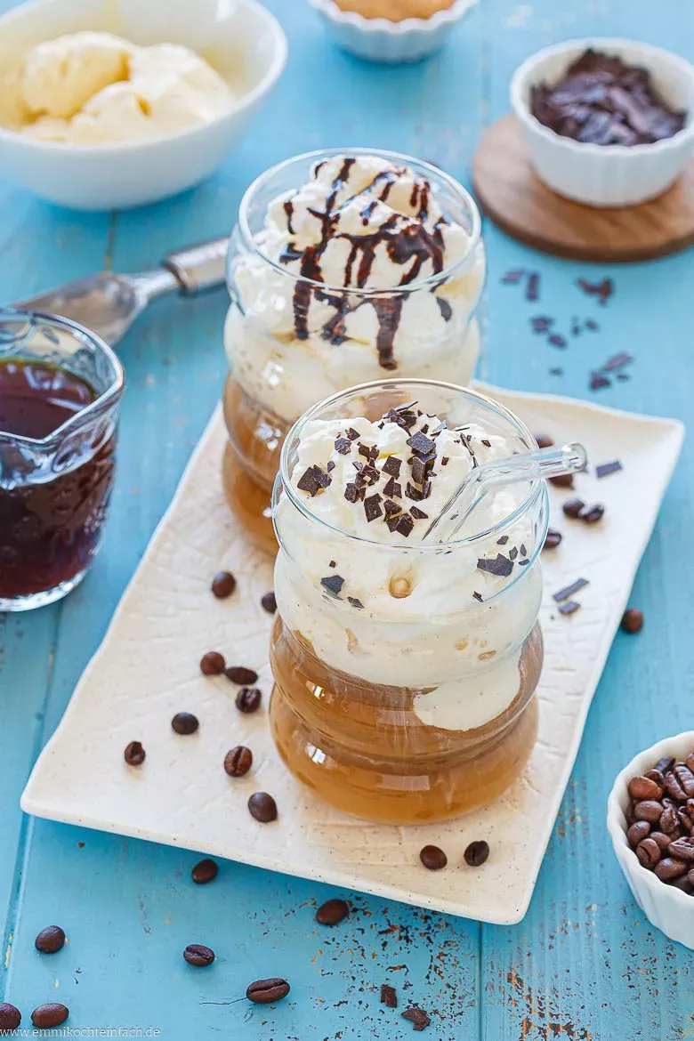 Ein Glas Eiskaffee mit Vanilleeis und viel Sahne auf einem Tablett