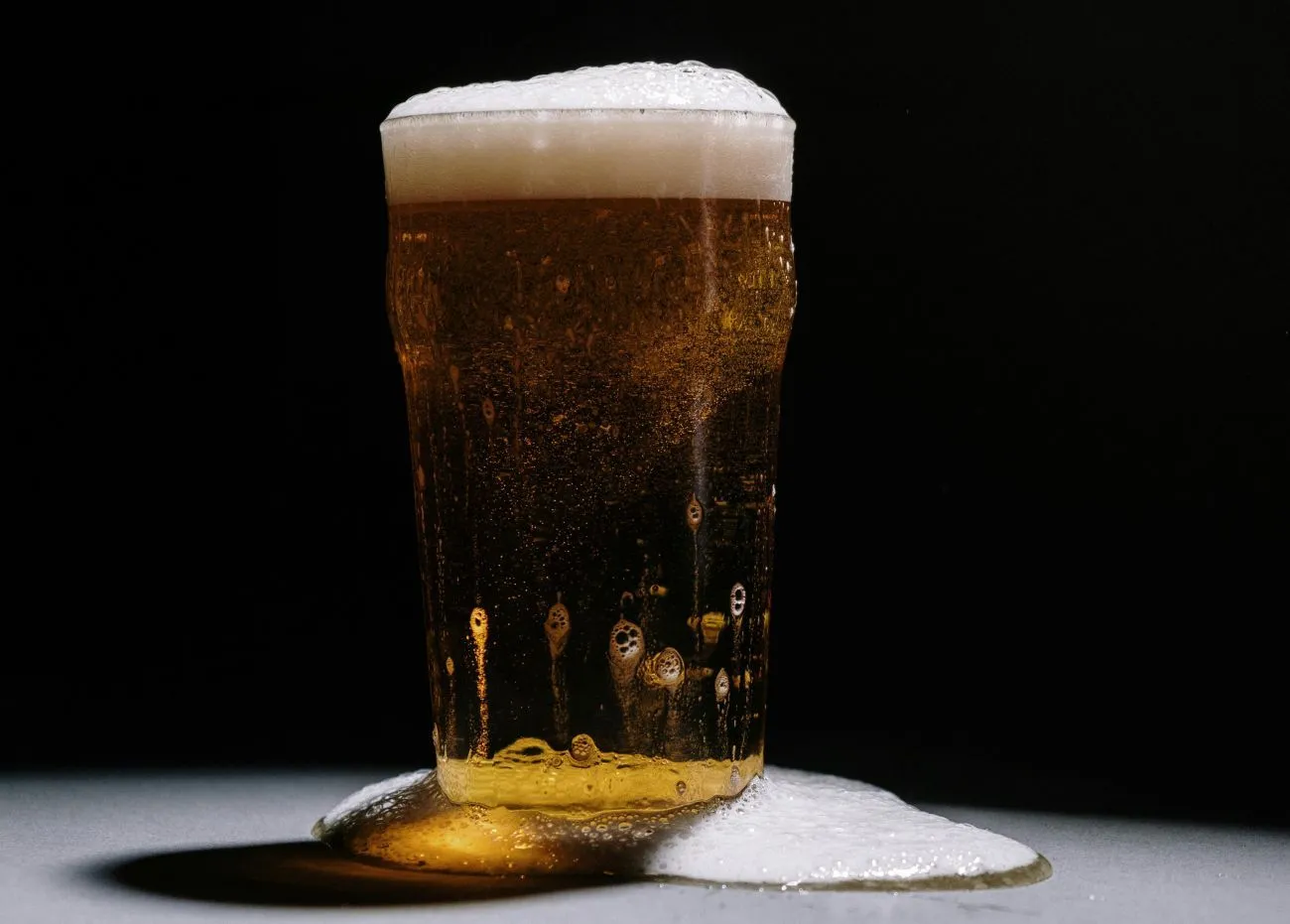 Ein kühles Radler mit Zitronenscheibe in einem Glas auf einem Holztisch.