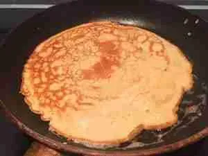 Ein Pfannkuchen wird in der Pfanne gewendet