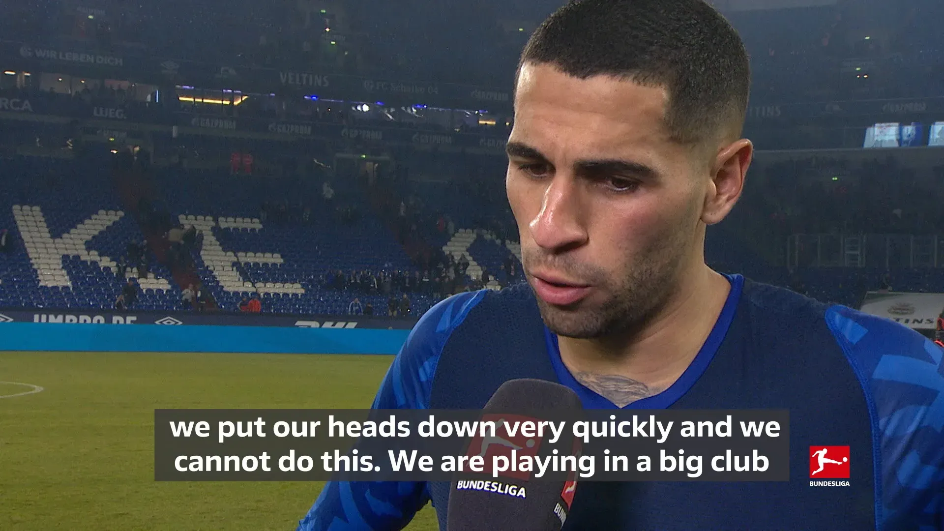 Ein Schalker Spieler (vermutlich Omar Mascarell) diskutiert mit dem Schiedsrichter, während andere Spieler im Hintergrund stehen