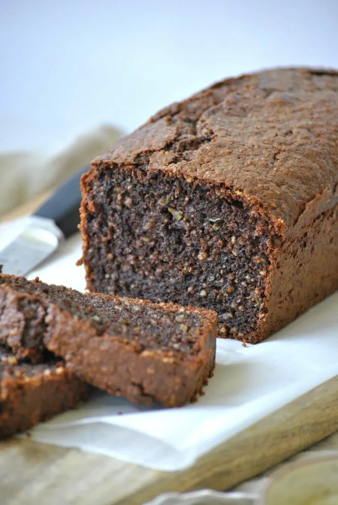 Ein Scheiben saftiger Zucchini Schoko Kuchen auf einem Holzbrett
