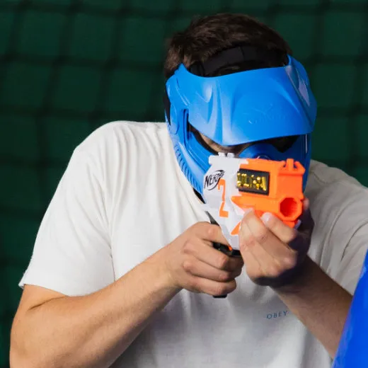 Ein Spieler zielt mit seinem Dart-Blaster auf dem Spielfeld