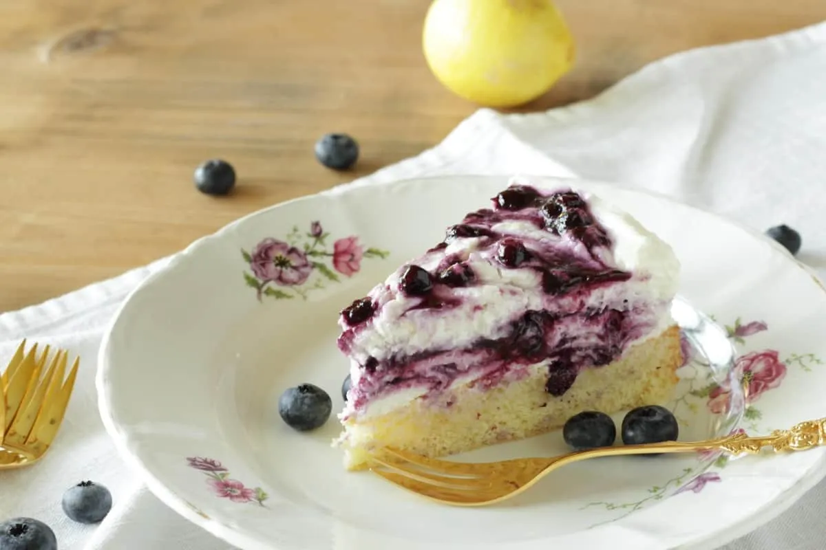 Ein Stück Blaubeer-Quark-Torte mit einer Gabel bereit zum Genießen