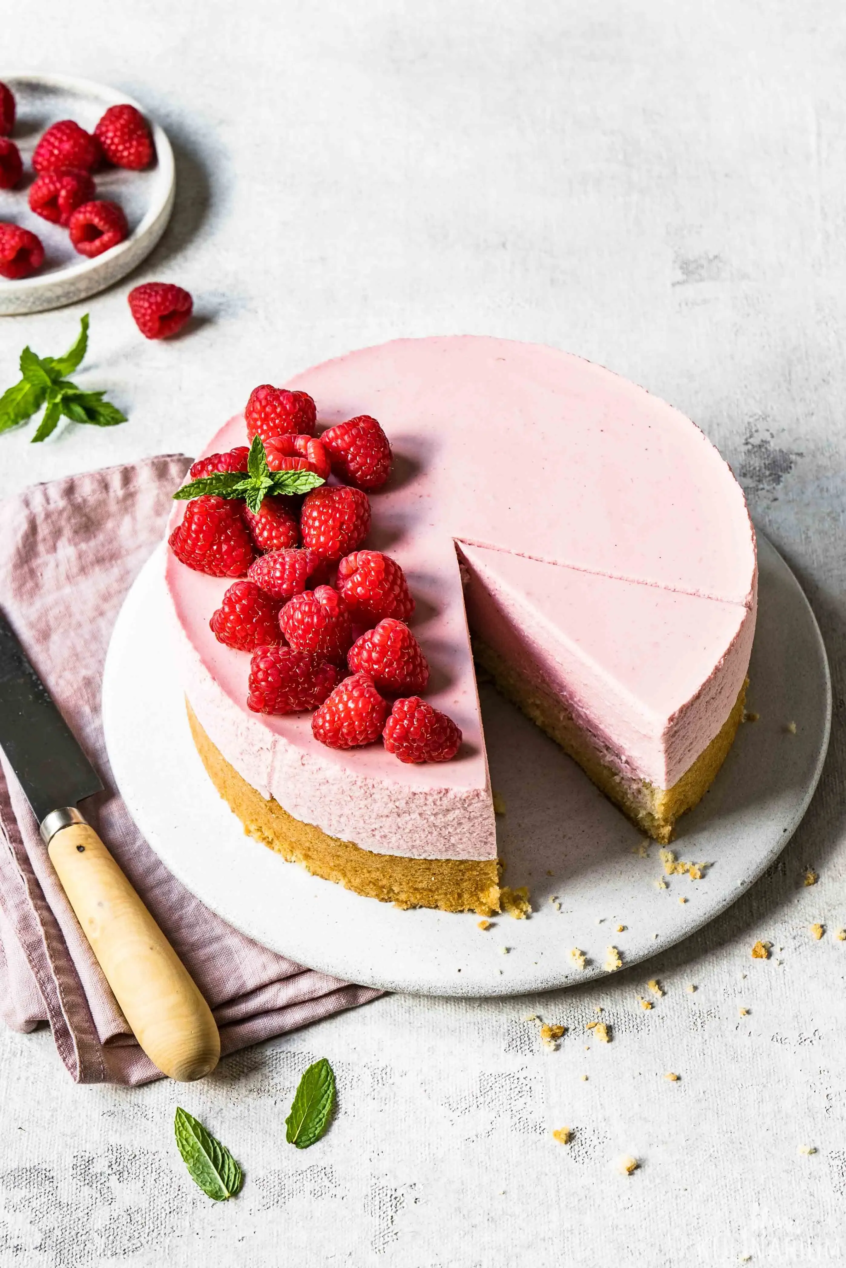 Ein Stück cremiger Himbeer-Sahne-Torte auf einem Teller