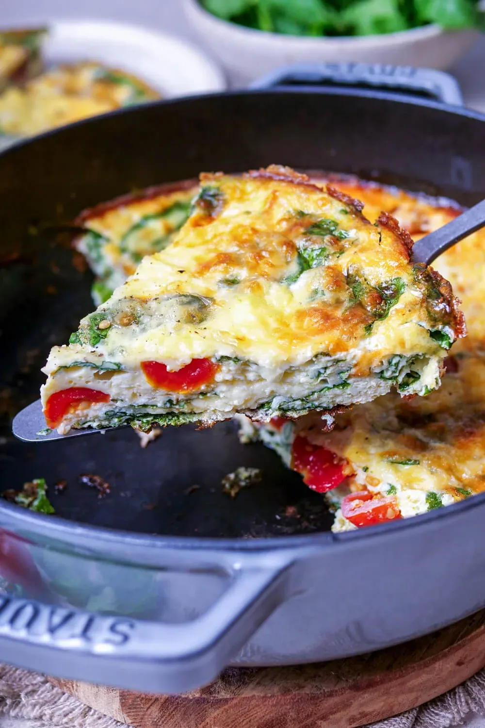 Ein Stück Frittata wird mit einem Pfannenwender aus der Pfanne genommen