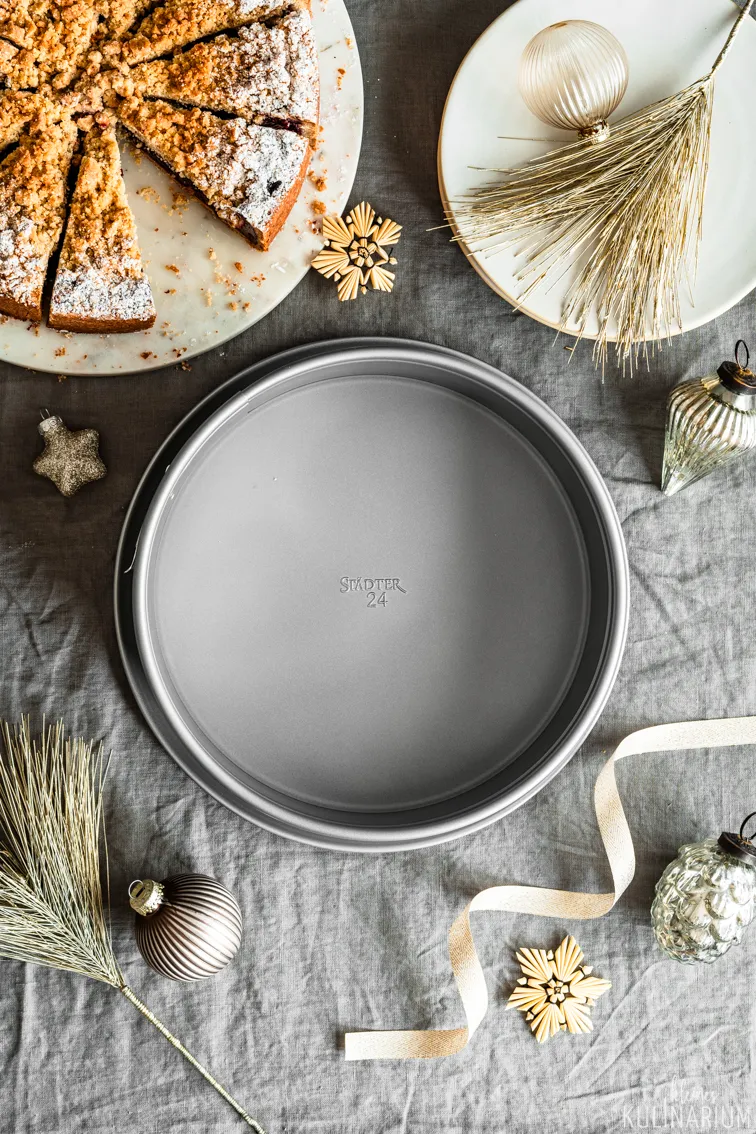 Ein Stück Kirsch-Streusel-Kuchen auf einem Teller mit weihnachtlicher Dekoration