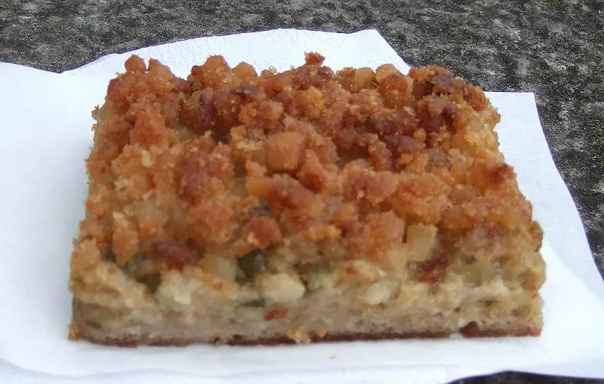 Ein Stück rustikaler Speckkuchen mit Roggenmehlkruste.