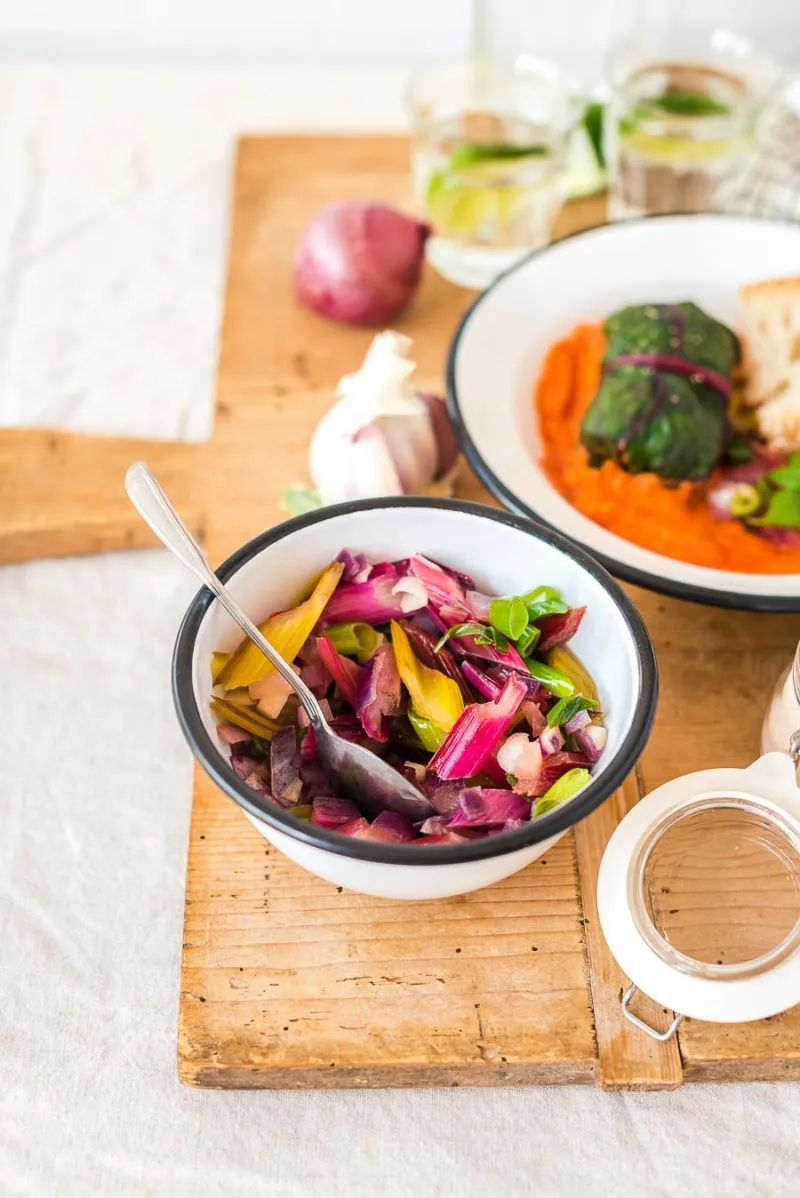 Ein Teller mit zwei Mangold Rouladen, bestreut mit frischen Kräutern