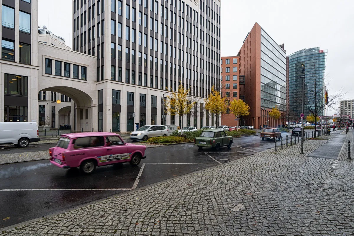 Ein Trabant fährt bei Regen durch die Straßen Berlins