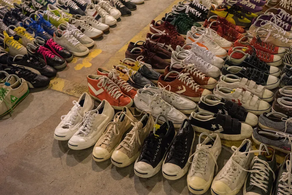 Ein Verkäufer präsentiert Vintage Converse-Sneakers auf dem Markt