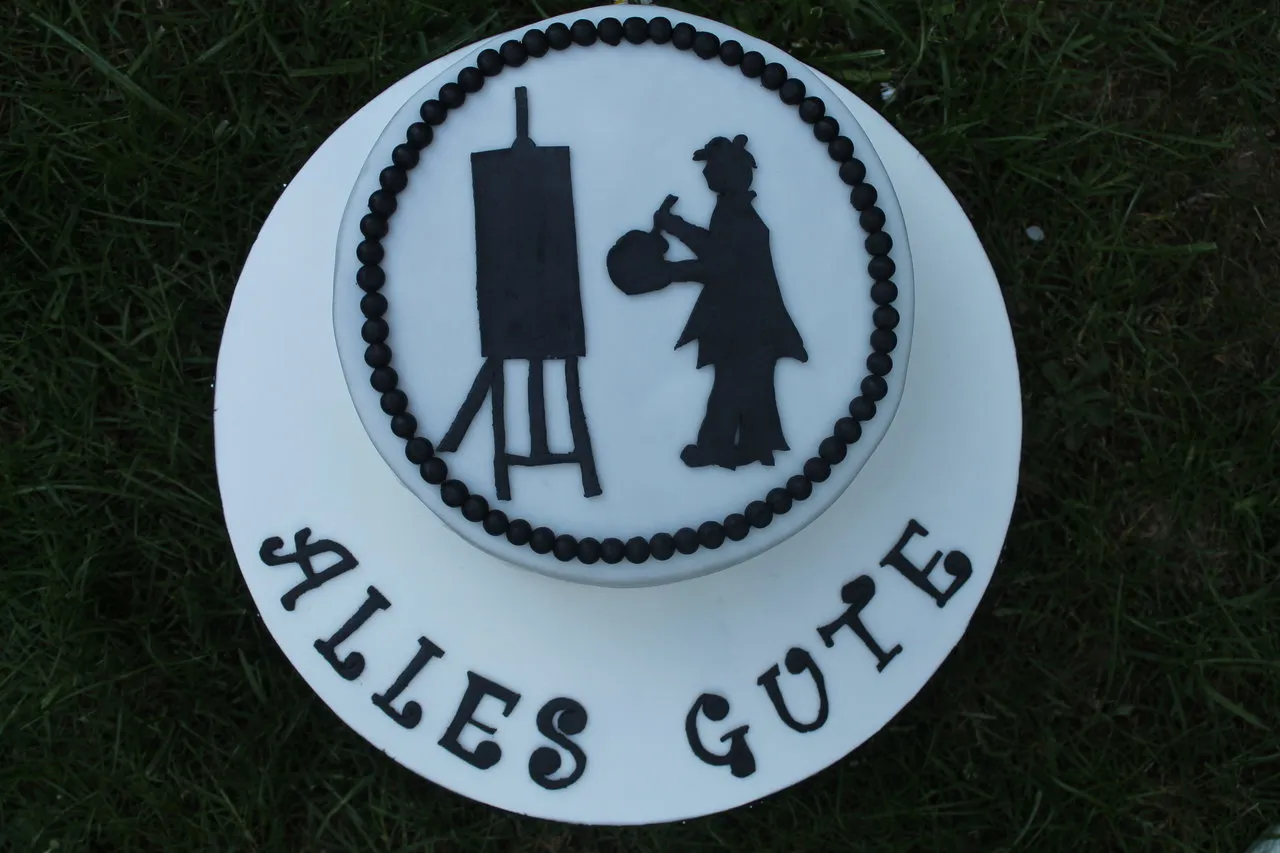 Ein weiteres Bild der Geburtstagstorte, die auf einem Tortenständer präsentiert wird