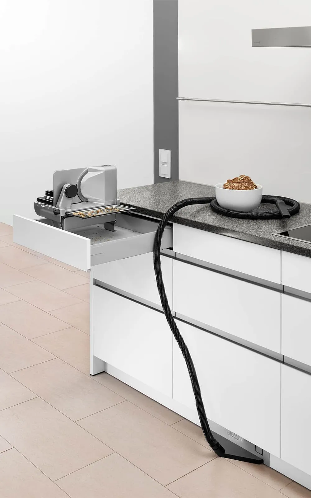 Einbau-Sockelsauger und Einbau-Allesschneider in einer modernen Küche