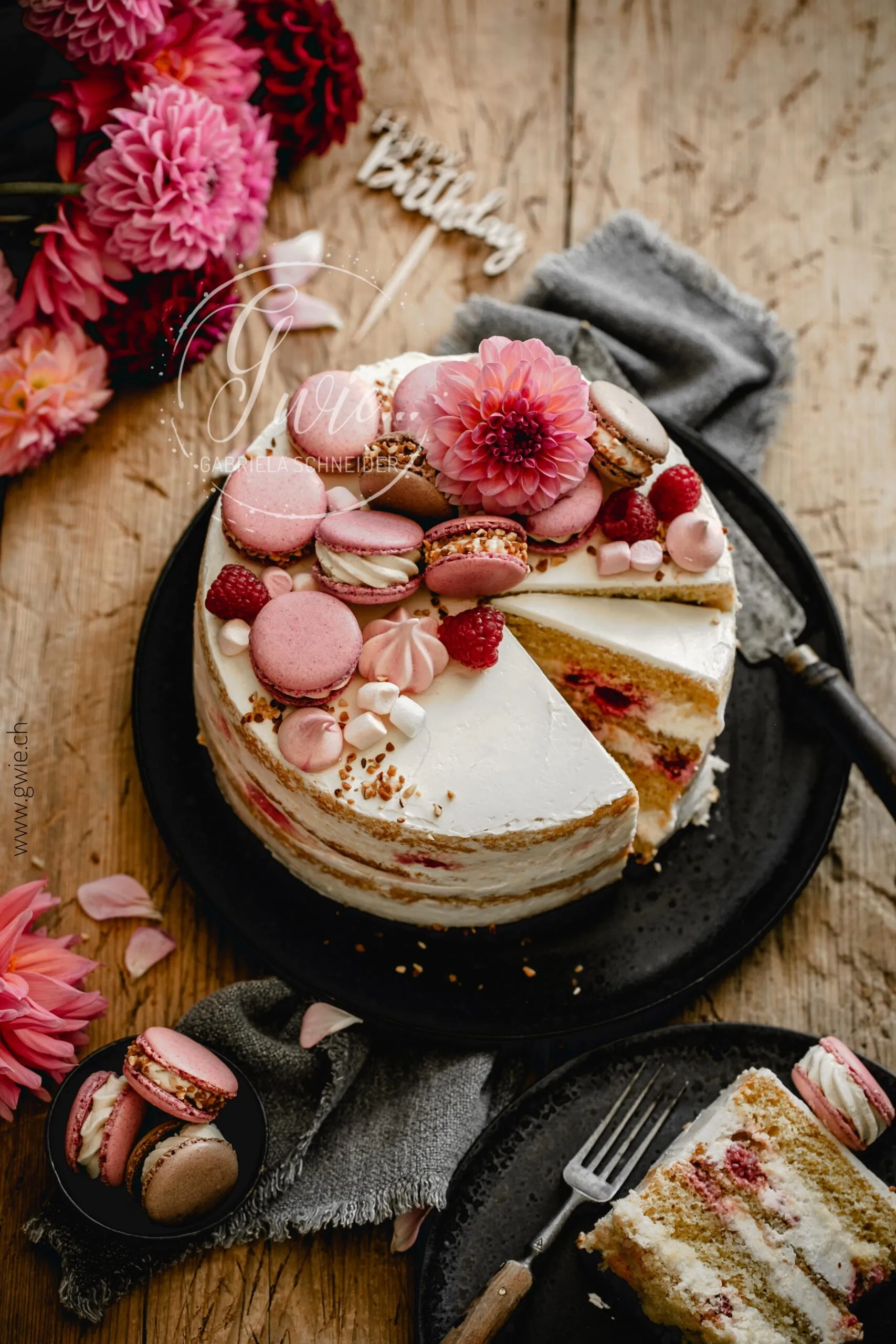 Eine Ansicht der angeschnittenen Geburtstagstorte mit Schichten von Creme und Himbeeren