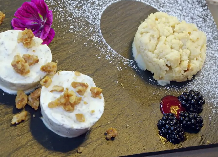 Eine exquisite Grillagetorte mit Birnenstreuseln und karamellisierten Walnüssen, serviert mit Nusseis