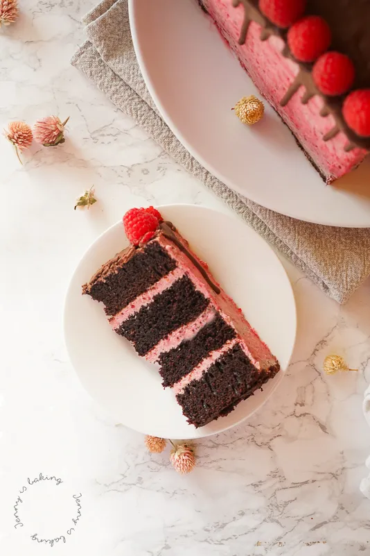 Eine fertige Himbeer-Schoko-Herztorte, von oben fotografiert, mit frischen Himbeeren und Schokolade