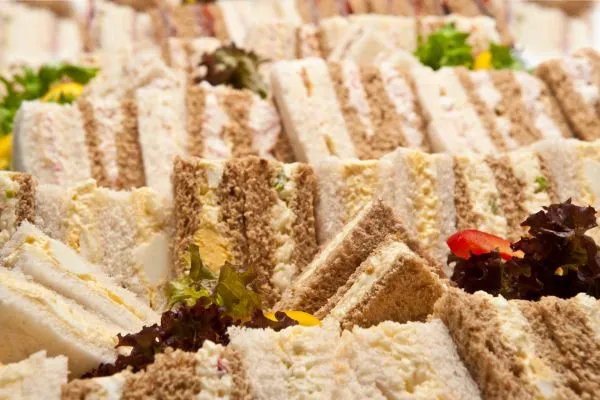 Eine festlich angerichtete Snackplatte mit Mini-Sandwiches und Gemüse