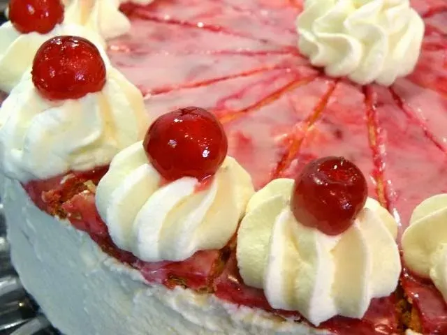 Eine festlich dekorierte Holländer Sahnetorte auf einer Kuchenplatte