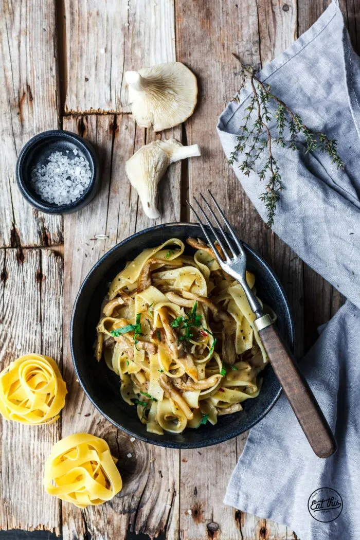 Eine Gabel voll Fettuccine mit Pilzen wird serviert