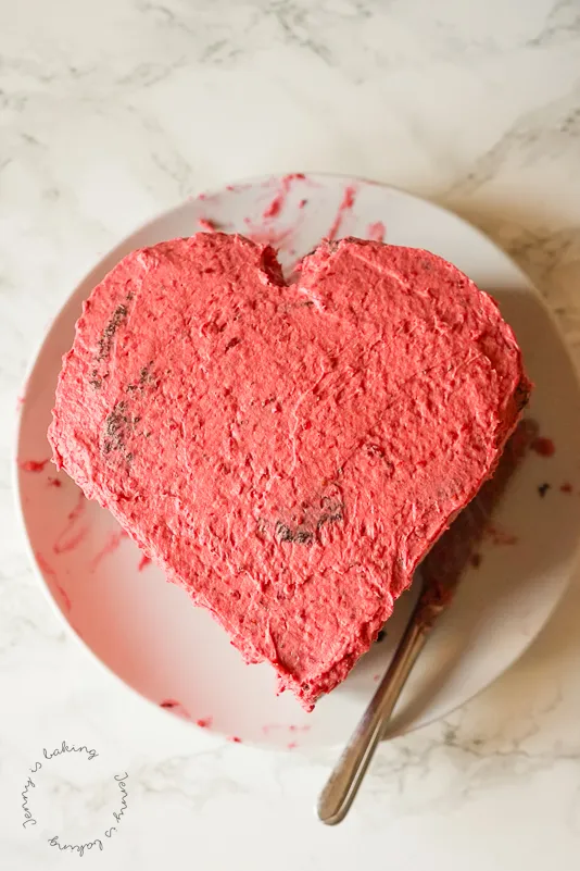 Eine Herztorte, die mit Buttercreme eingestrichen wird, um die Konturen zu glätten und die Herzform zu betonen