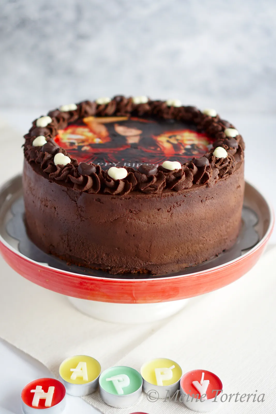 Eine liebevoll dekorierte Geburtstagstorte mit einem individuellen Tortenaufleger