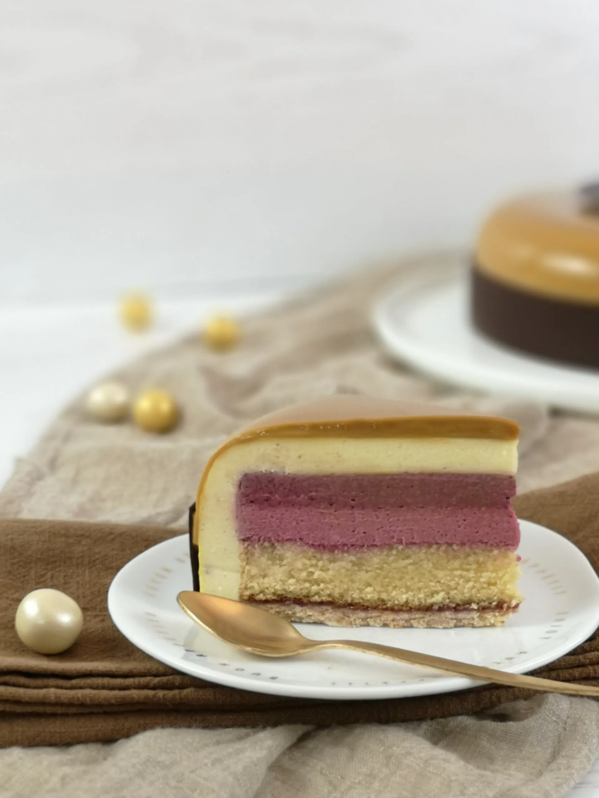 Eine Nahaufnahme der glasierten Torte mit einem goldenen Schokoladenring als Dekoration