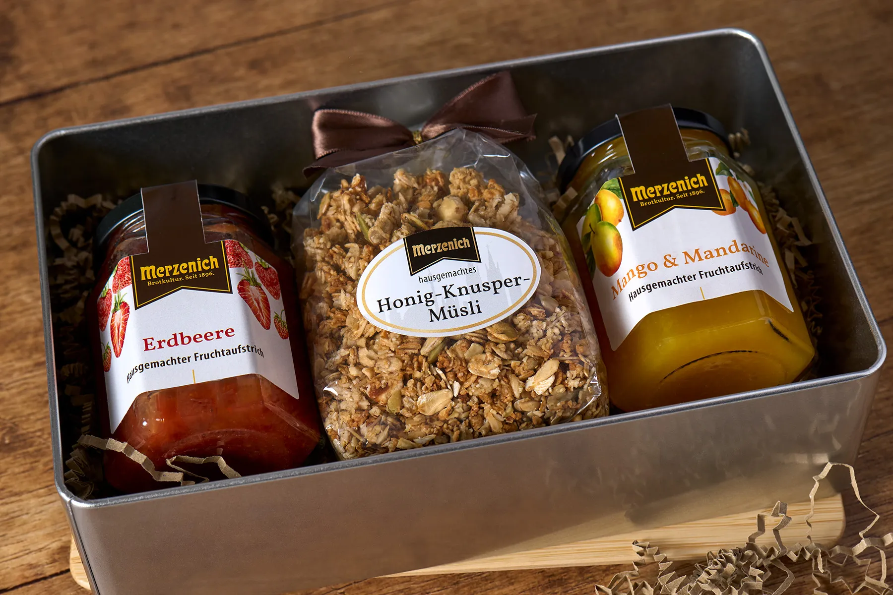 Eine offene Geschenkbox mit Marmeladen und Müsli