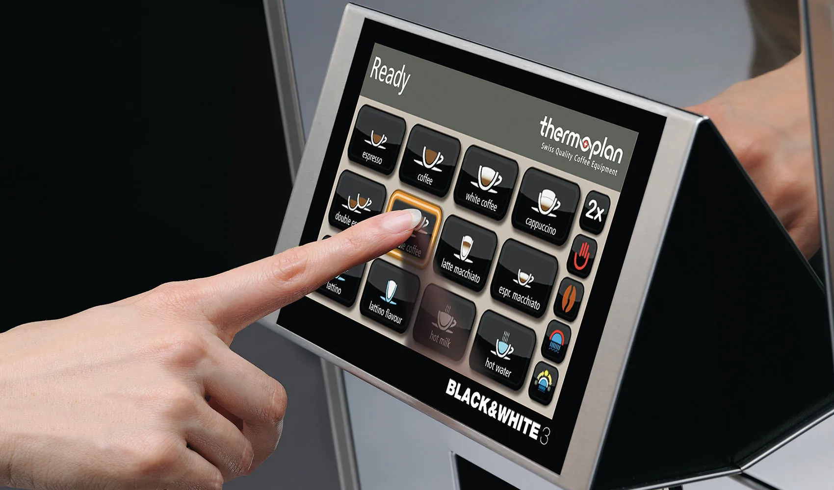 Eine Person bedient einen Touchscreen einer Thermoplan Kaffeemaschine