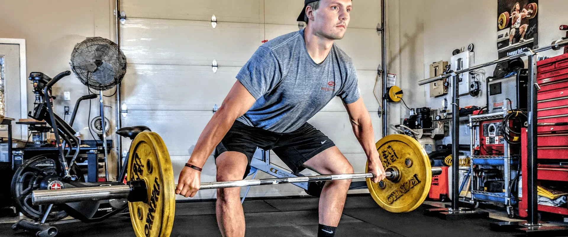 Eine Person beim Krafttraining mit einer Langhantelstange, die sich auf den Po Muskelaufbau konzentriert
