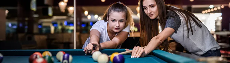 Eine Person zielt auf eine Billardkugel auf einem Snookertisch