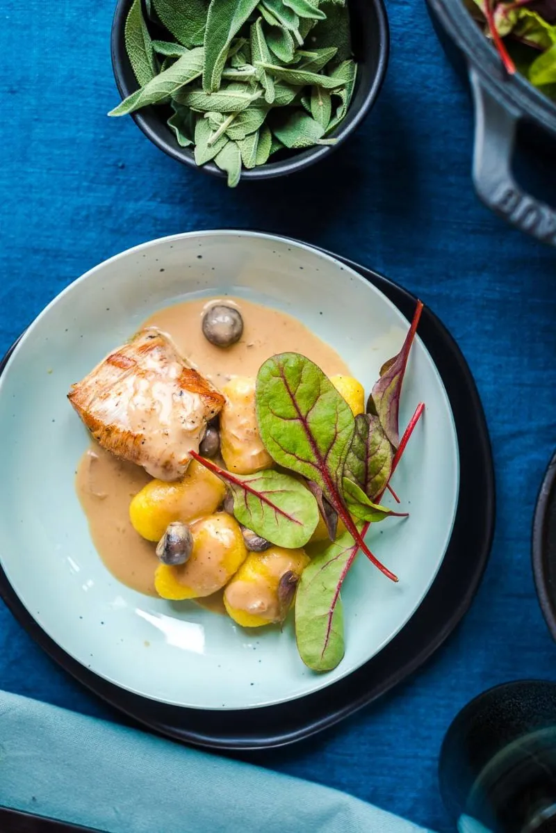 Eine Portion Schweinefilet mit Gnocchi und Mangold auf einem Teller