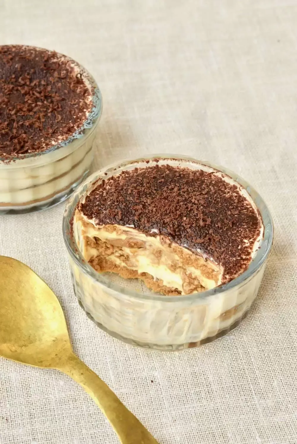 Eine Portion veganes Tiramisu in einem Glas, das die Schichten im Inneren enthüllt.